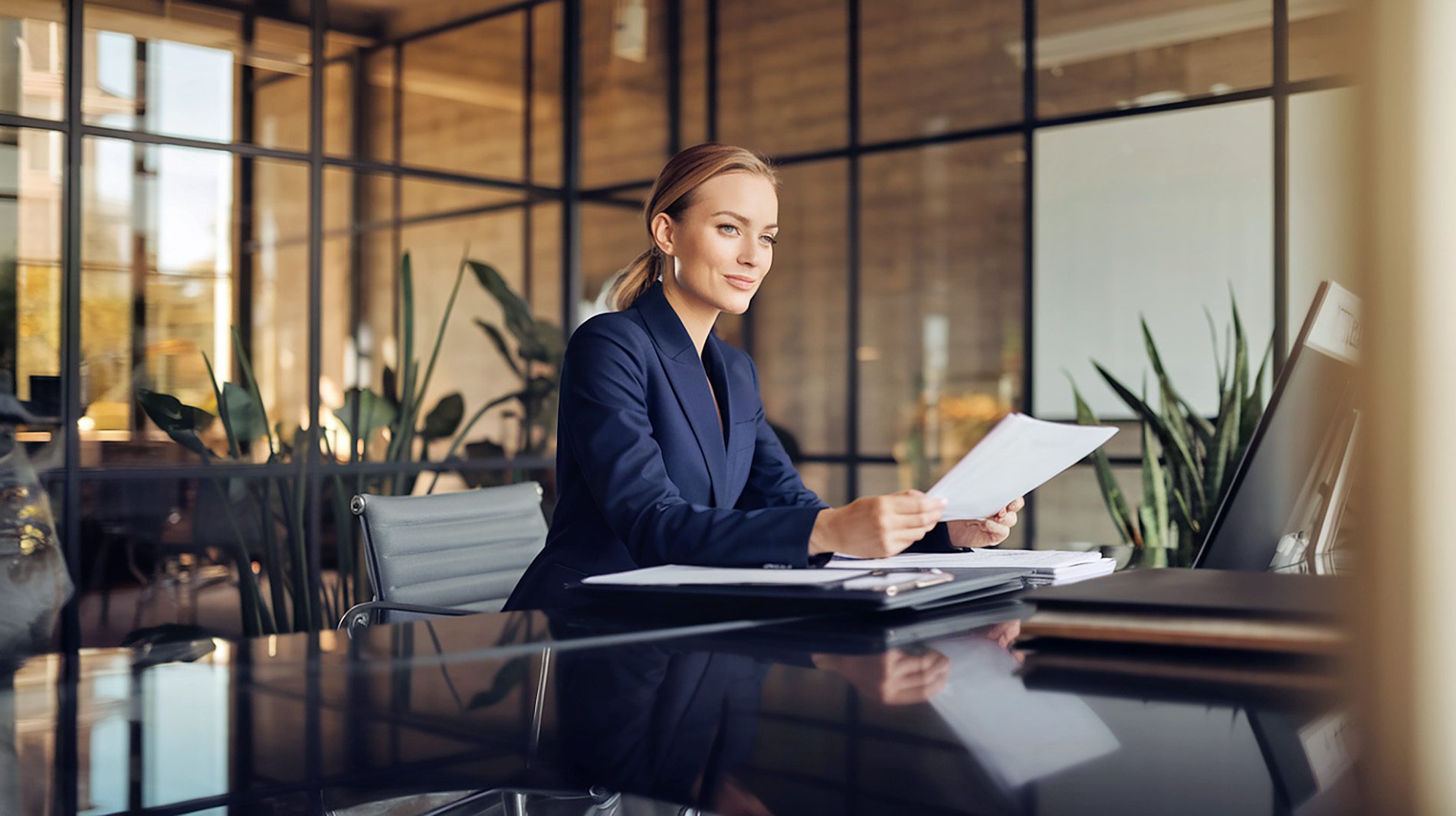 Professionelle Anwältin, die am modernen Schreibtisch mit Dokumenten arbeitet