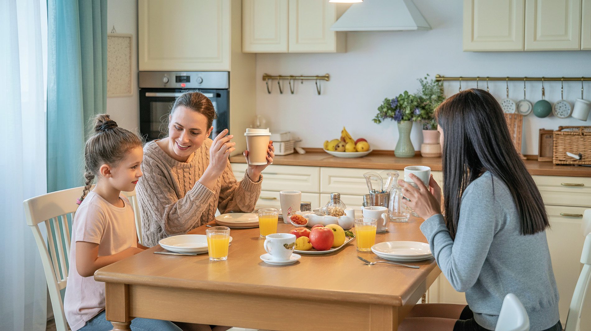 Eine Familie beim Frühstück in einer hellen Küche.